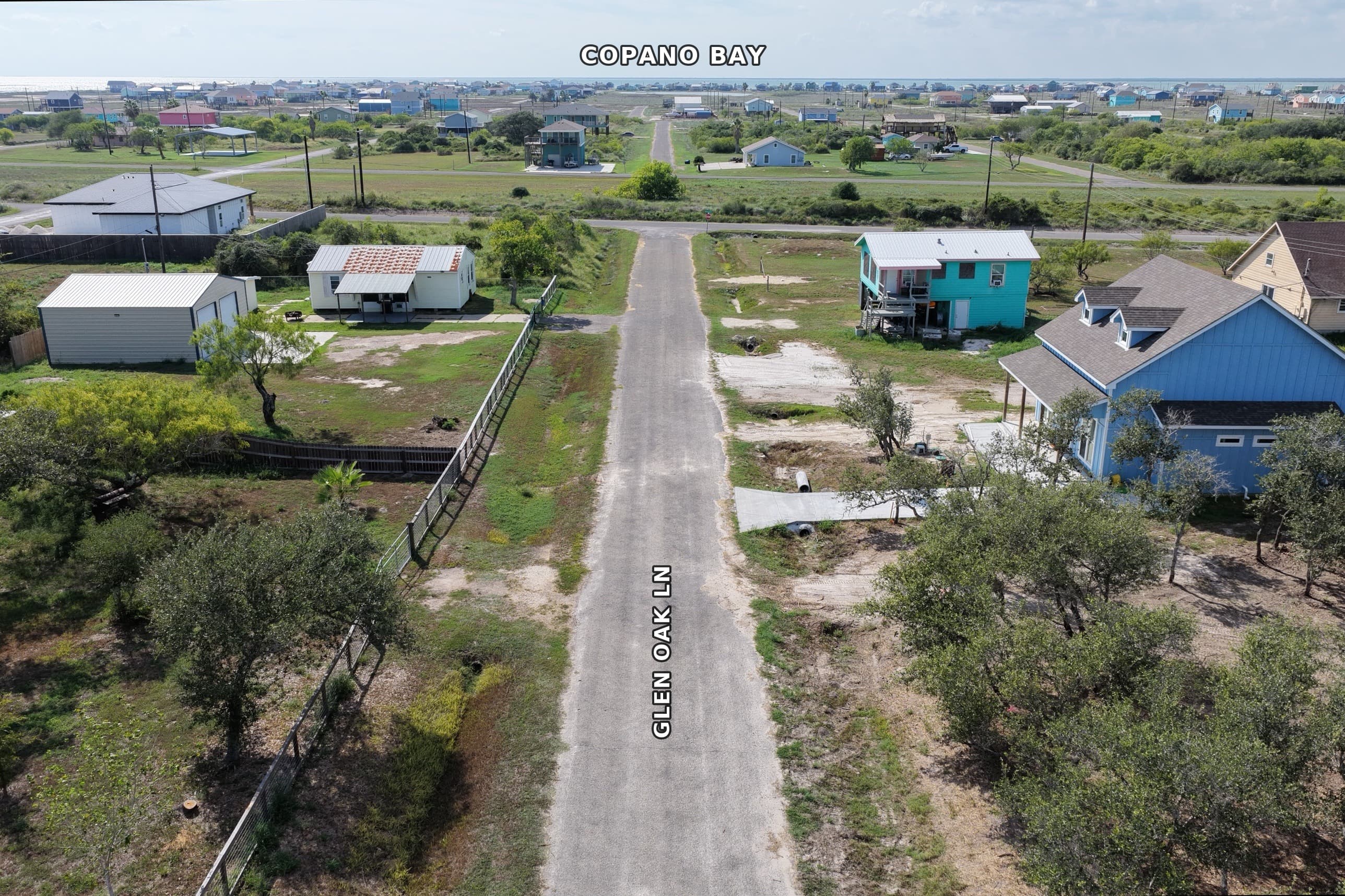 Aerial view of Glen Oak Lane with colorful coastal houses and Copano Bay background.