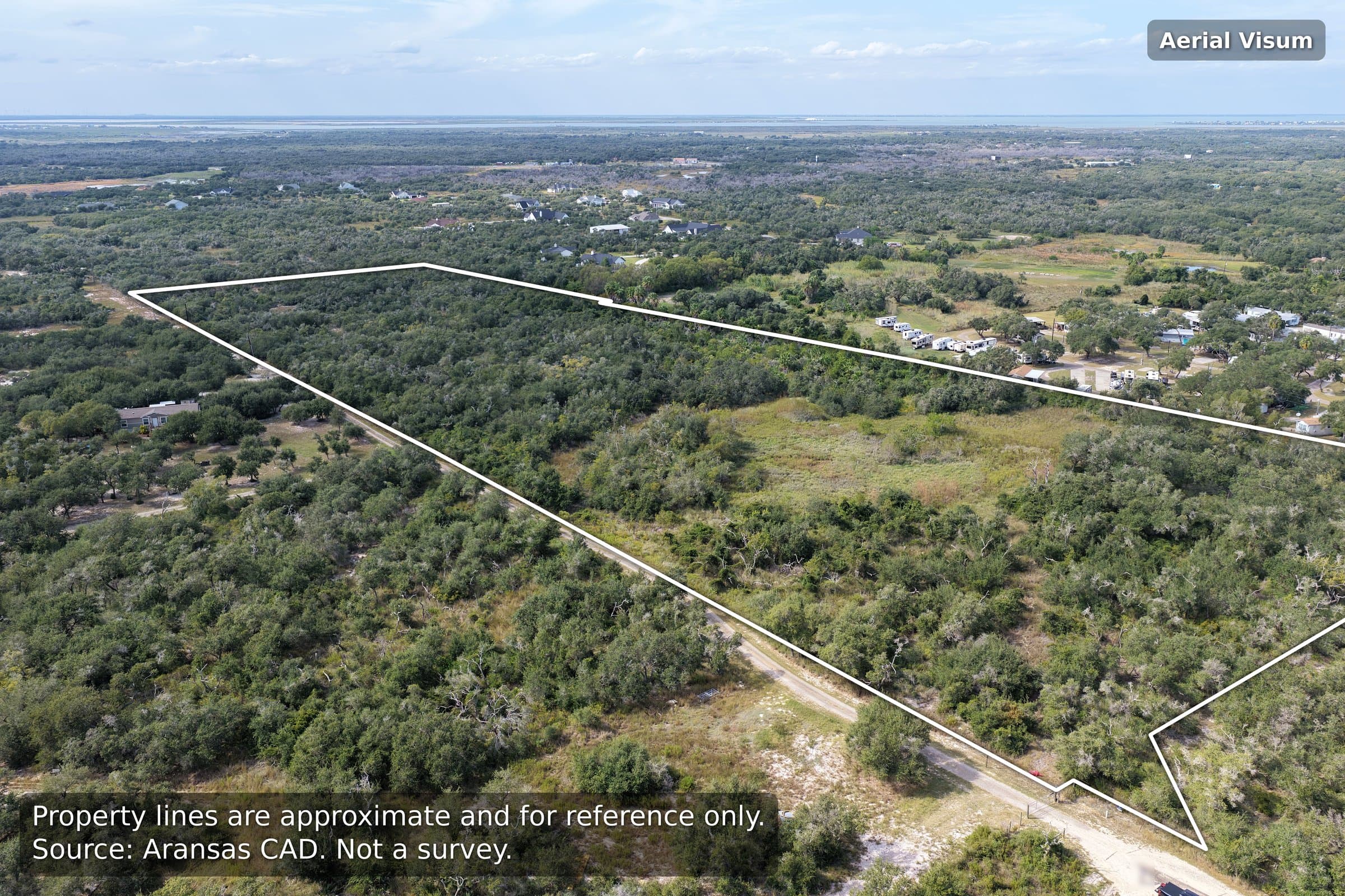 Aerial view of a large, rectangular wooded lot outlined with white property boundary lines.
