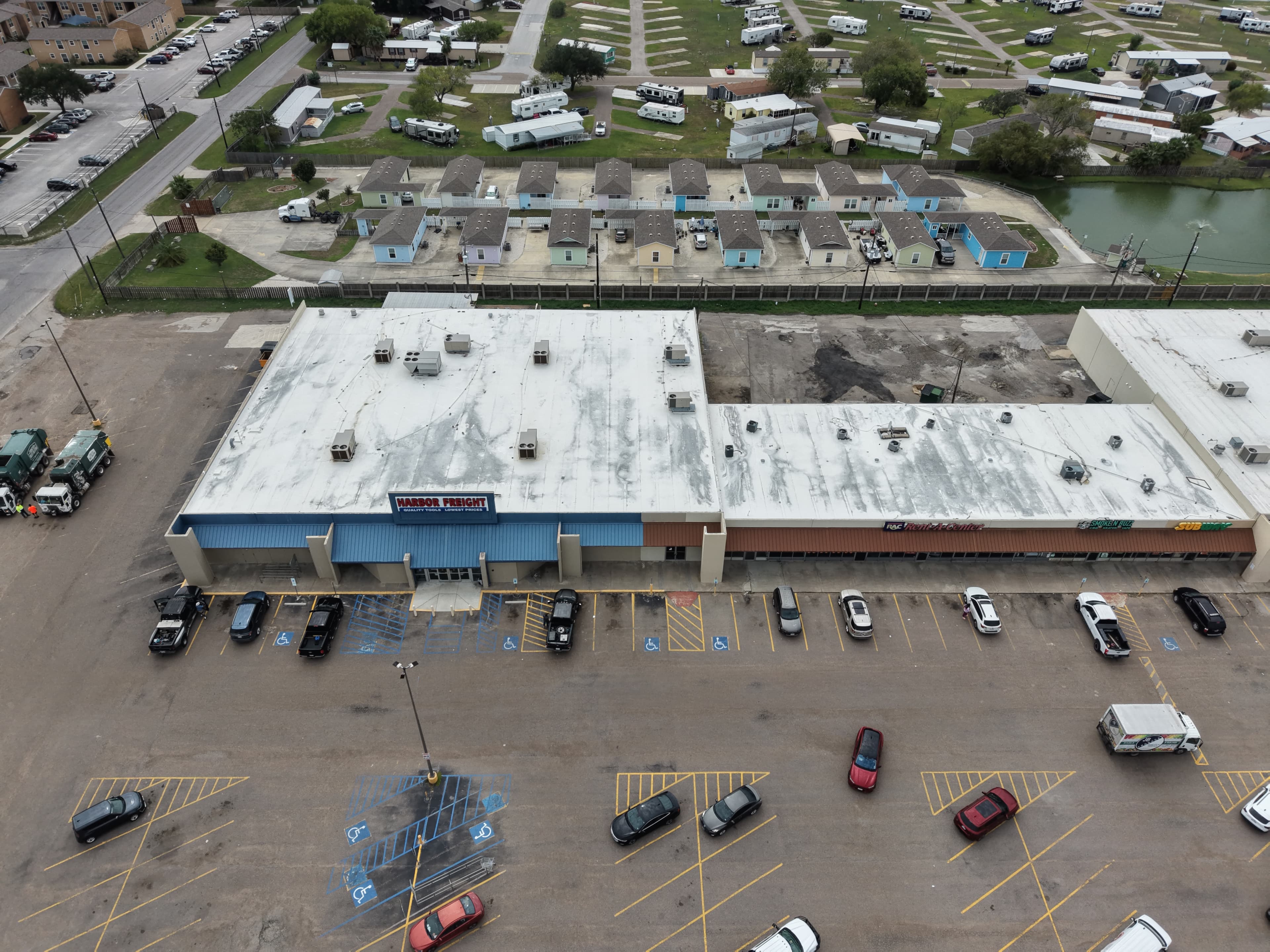 Aerial view of a Harbor Freight strip mall adjacent to a colorful residential community.